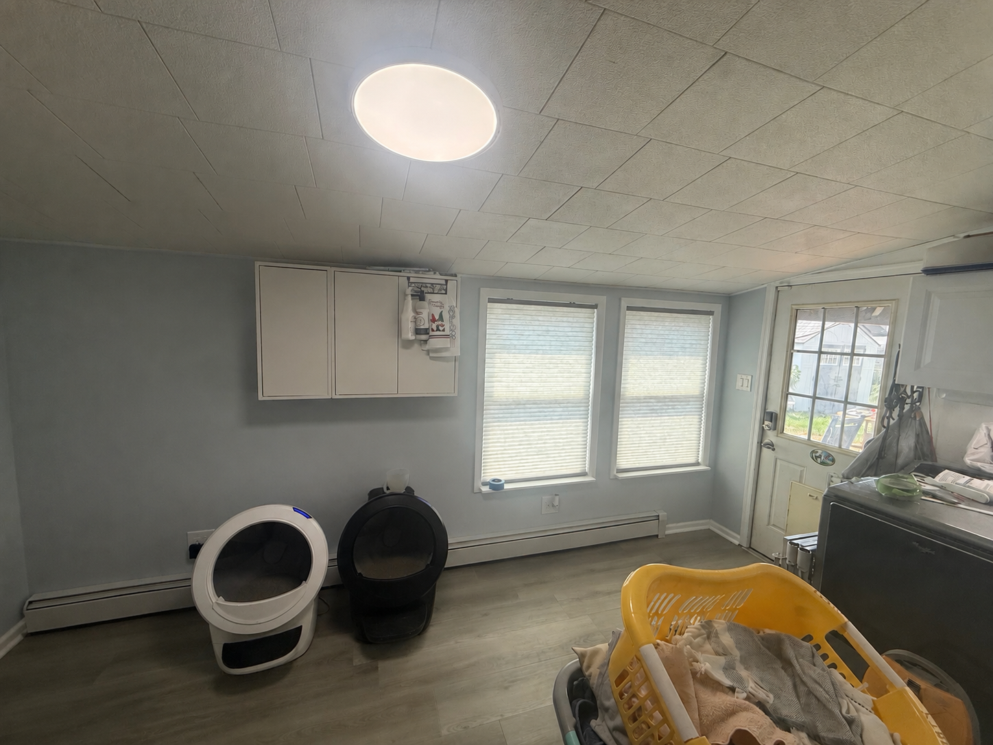 The finished room with gray walls, white window trim, fitted shades, and completed flooring